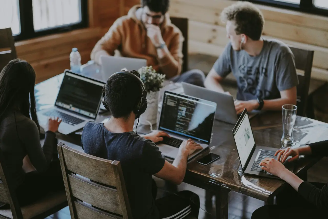 Engineers working together at a bank of monitors.
